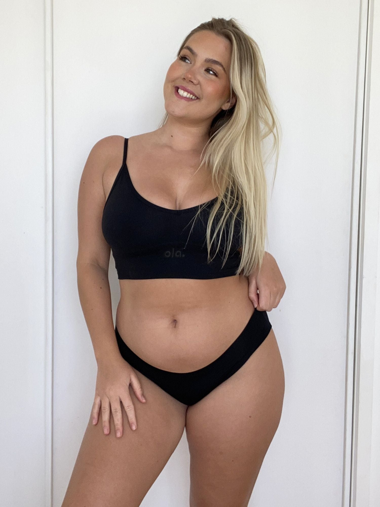 Woman wearing an Ola V crop and Bikini Brief against a white background