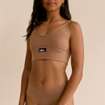 Larni Slightly side on wearing matching Ola set V Crop and Bikini Thong in Hot Fudge