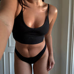 Person wearing a black V Crop and underwear set with 'ola' branding.