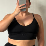 Person wearing a black Ola V Crop with 'ola' branding against a neutral background