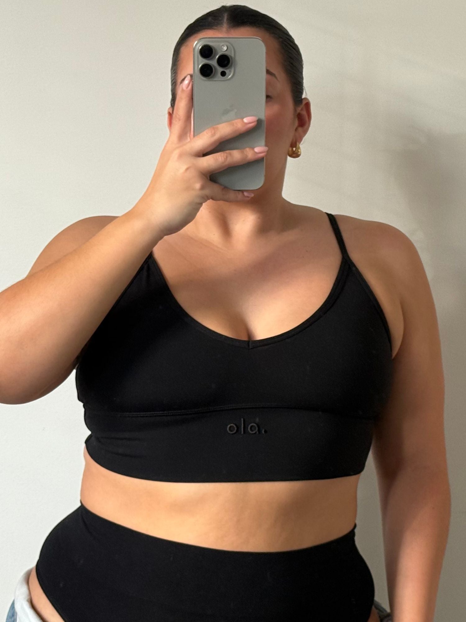 Person wearing a black Ola V Crop with 'ola' branding against a neutral background